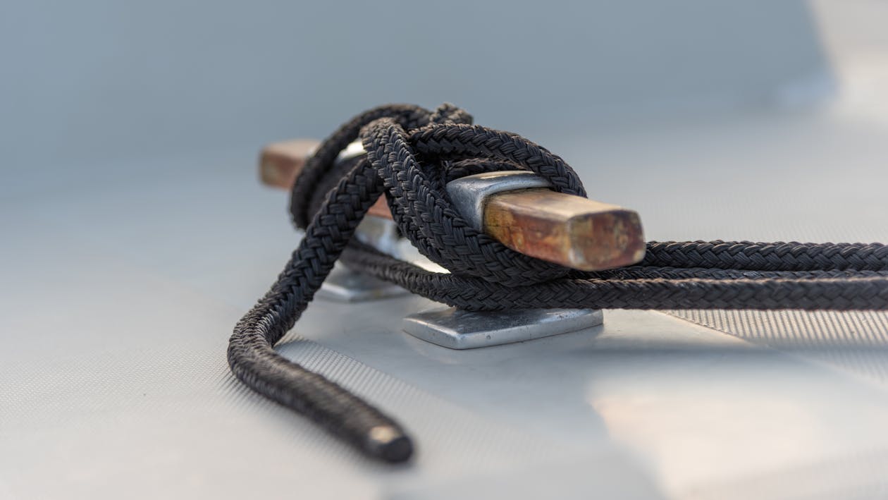Mooring rope securely tied around a cleat on a yacht deck